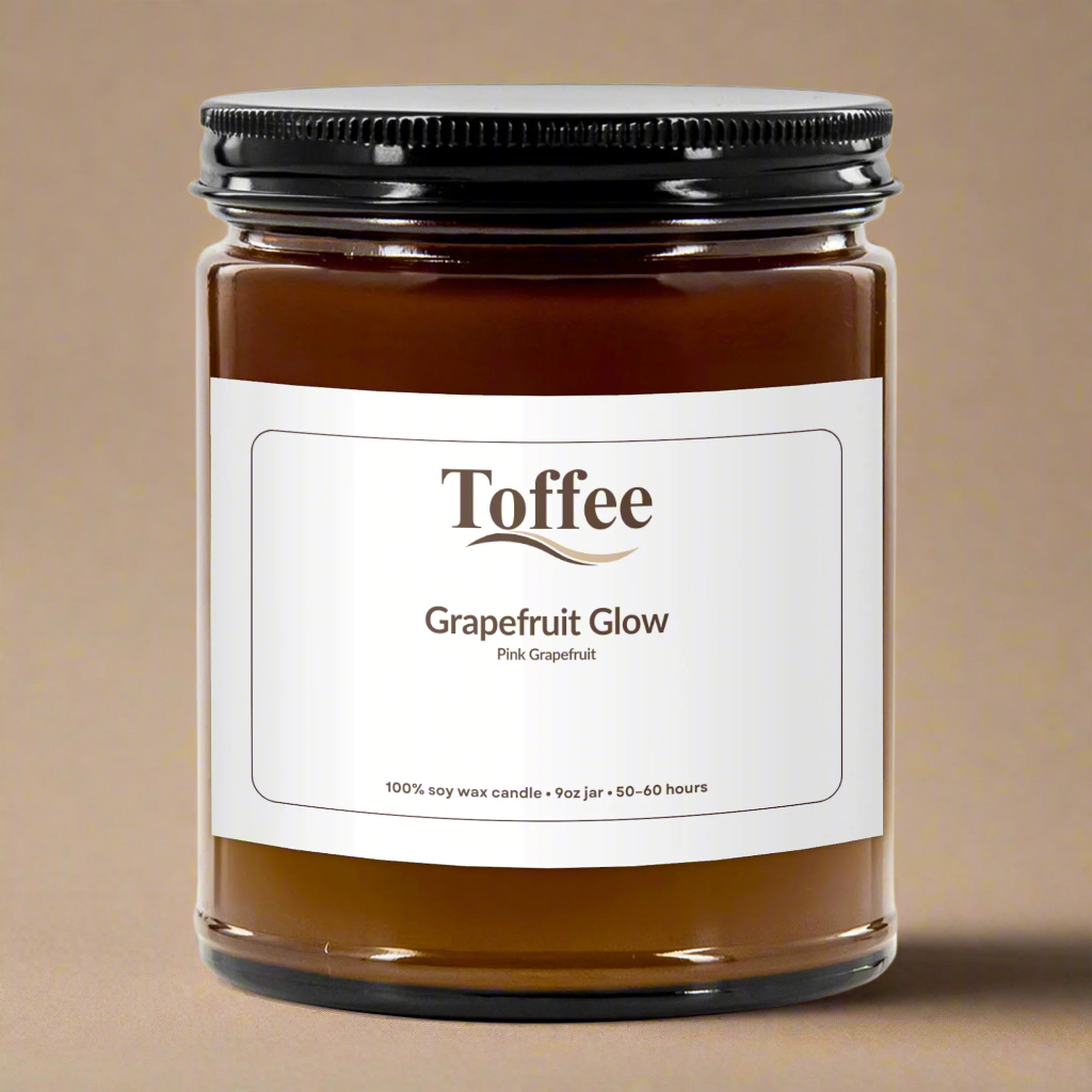 Jar of Toffee Grapefruit Glow candle with a white label on a white background