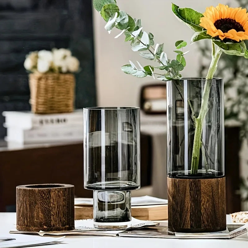 Decorative glass vases with wooden bases on a table.